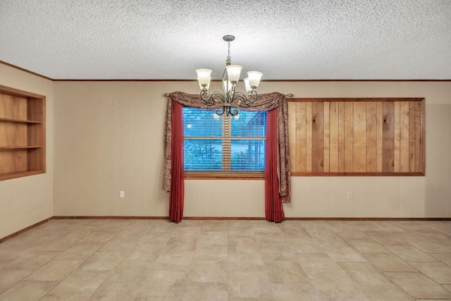 116 W Robinson Rd, Big Spring, TX 79720 - empty room with a chandelier, a textured ceiling, crown molding, built in features, and wooden walls