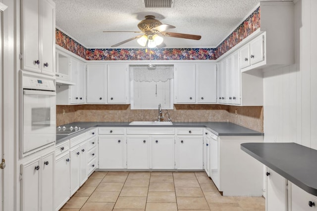 116 W Robinson Rd, Big Spring, TX 79720 - kitchen with white oven, a sink, ceiling fan, black electric cooktop, and a textured ceiling