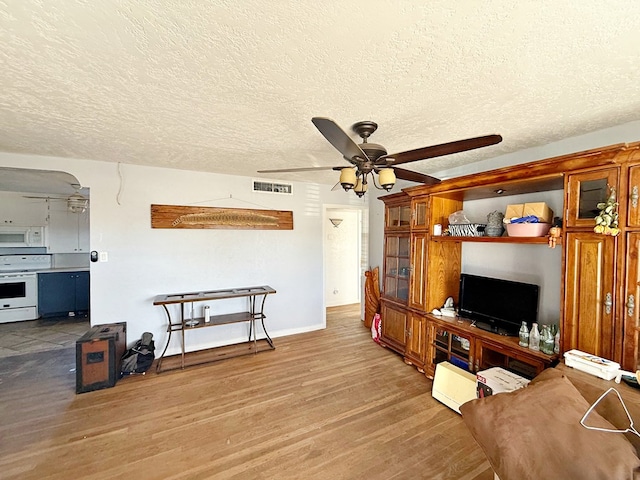 living room featuring ceiling fan, wood-type flooring, and a textured ceiling