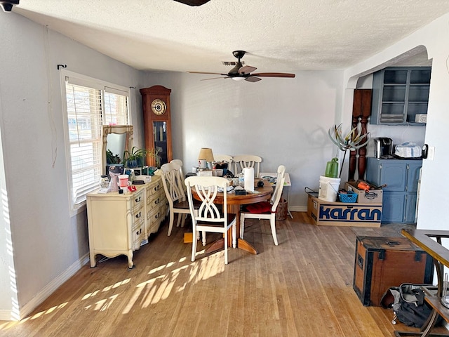 dining area with ceiling fan, light hardwood / wood-style floors, and a textured ceiling