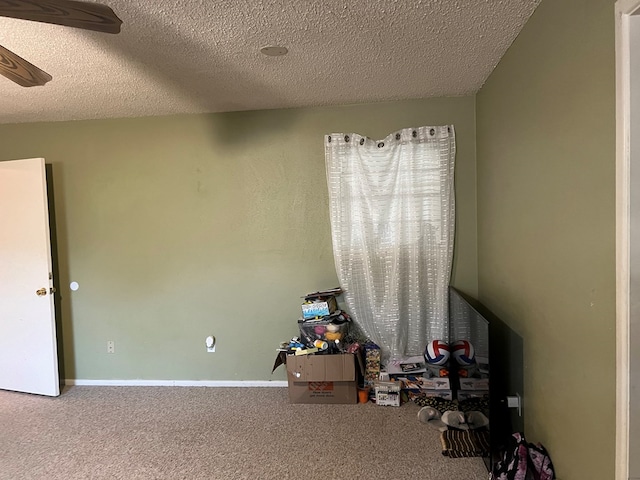 game room with ceiling fan, a textured ceiling, carpet flooring, and baseboards