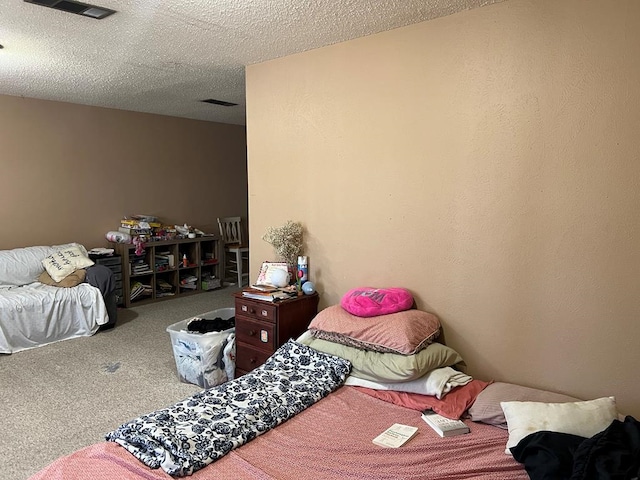 carpeted bedroom featuring a textured ceiling and visible vents