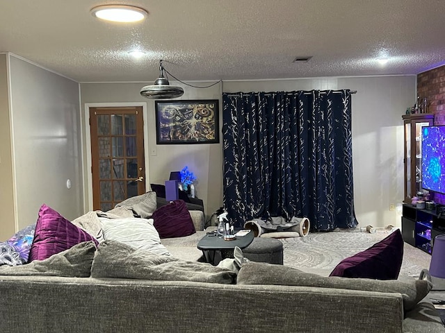 living room with carpet, visible vents, and a textured ceiling