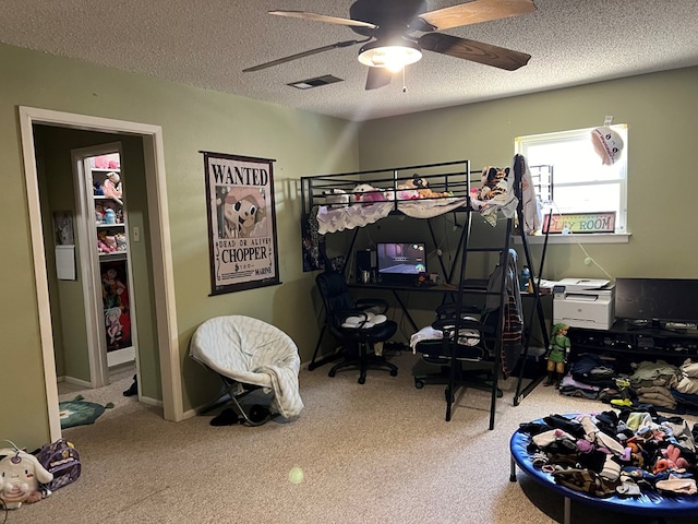 bedroom with carpet floors, ceiling fan, and a textured ceiling