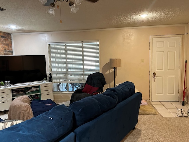 carpeted living area with a textured ceiling, ceiling fan, visible vents, and tile patterned floors