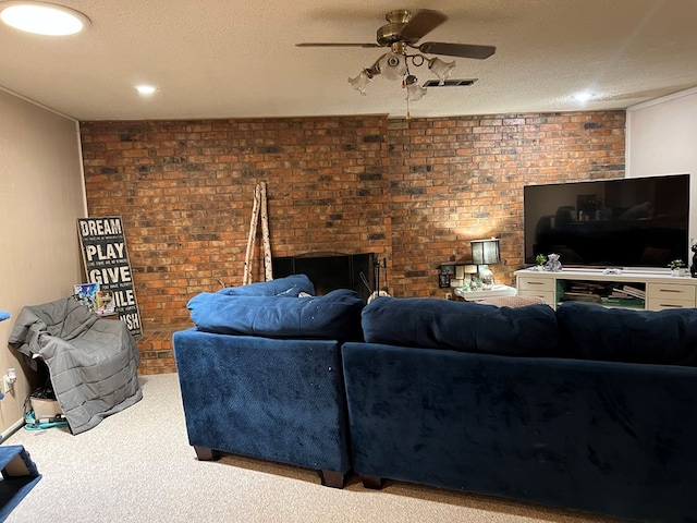 carpeted living area featuring a ceiling fan, visible vents, a textured ceiling, and brick wall