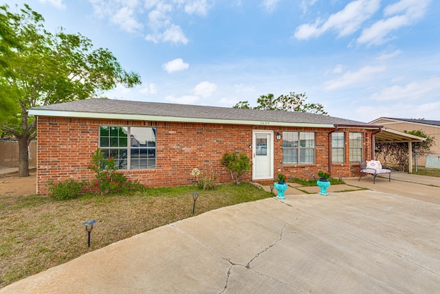 1609 E Pecan Ave, Midland, TX 79705 - view of front facade with concrete driveway, brick siding, an attached carport, and a front yard
