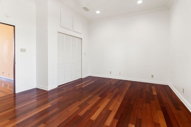 unfurnished bedroom featuring crown molding, a closet, and dark wood-type flooring