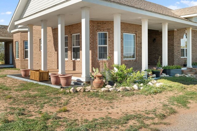 view of side of property featuring covered porch