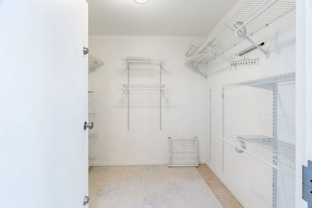 walk in closet featuring light tile patterned flooring