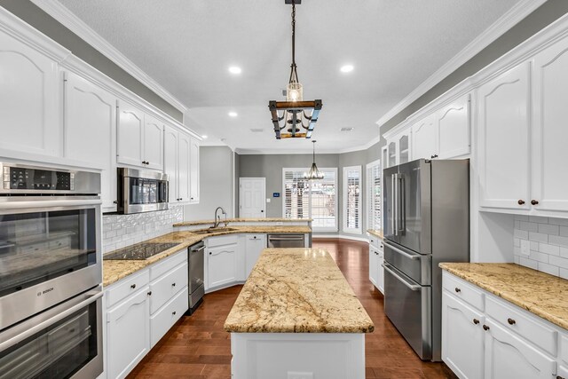 2201 Hereford Blvd, Midland, TX 79707 - kitchen with appliances with stainless steel finishes, a center island, a peninsula, a chandelier, and ornamental molding