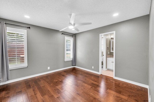 2201 Hereford Blvd, Midland, TX 79707 - unfurnished bedroom with a textured ceiling, multiple windows, and wood finished floors