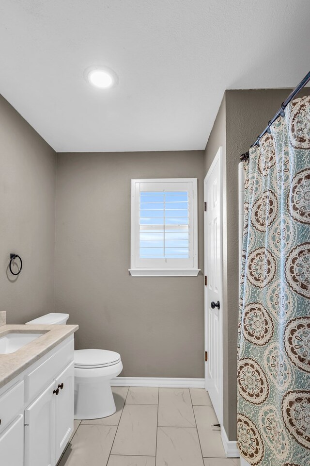 2201 Hereford Blvd, Midland, TX 79707 - bathroom featuring curtained shower, vanity, baseboards, toilet, and marble finish floor
