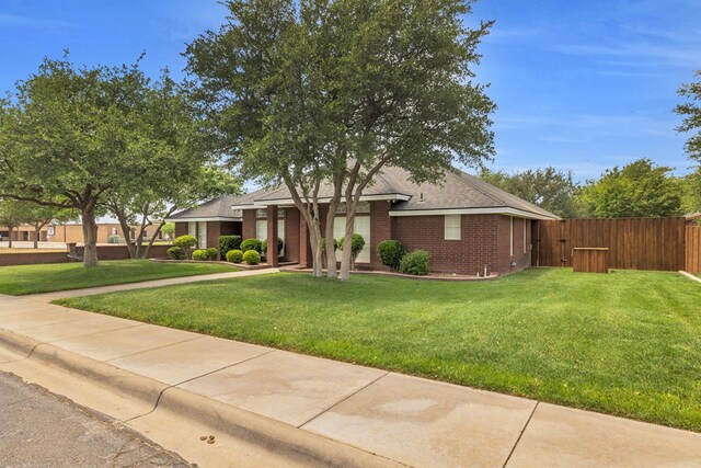 2201 Hereford Blvd, Midland, TX 79707 - view of front of property featuring brick siding, fence, roof with shingles, and a front lawn