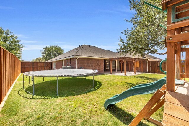 2201 Hereford Blvd, Midland, TX 79707 - view of yard with a fenced backyard, a trampoline, a playground, and a pergola