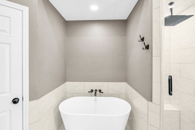 2201 Hereford Blvd, Midland, TX 79707 - full bath featuring wainscoting, recessed lighting, a freestanding tub, tile walls, and a stall shower