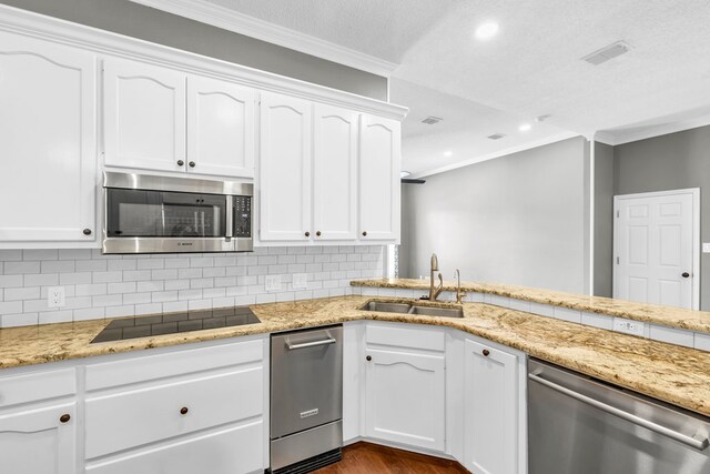 2201 Hereford Blvd, Midland, TX 79707 - kitchen with visible vents, appliances with stainless steel finishes, a sink, white cabinets, and ornamental molding