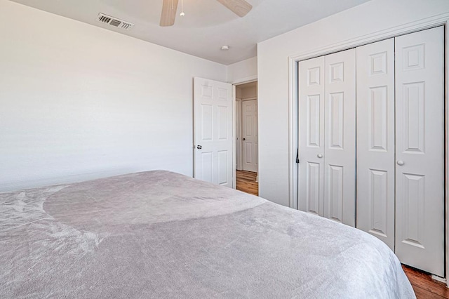 carpeted bedroom featuring ceiling fan and a closet