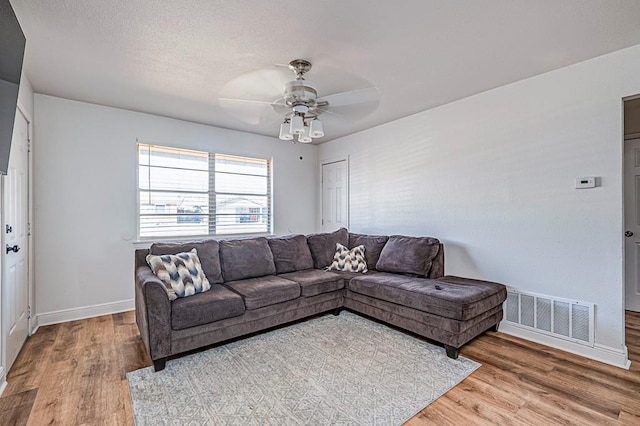 living room with hardwood / wood-style floors and ceiling fan