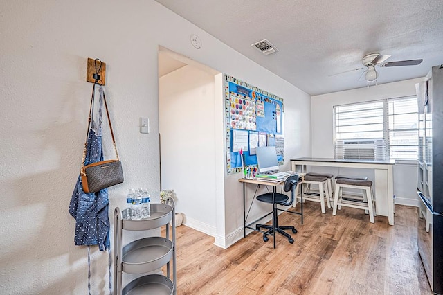 office area featuring ceiling fan, cooling unit, light hardwood / wood-style floors, and a textured ceiling