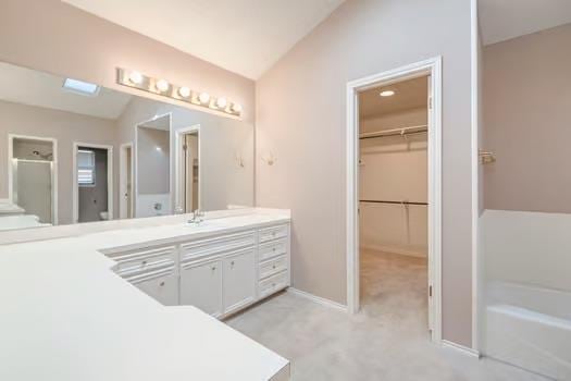 bathroom featuring vanity, an enclosed shower, and vaulted ceiling