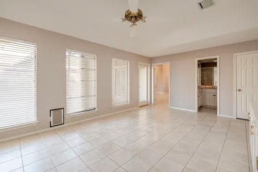 unfurnished room featuring light tile patterned floors and an inviting chandelier