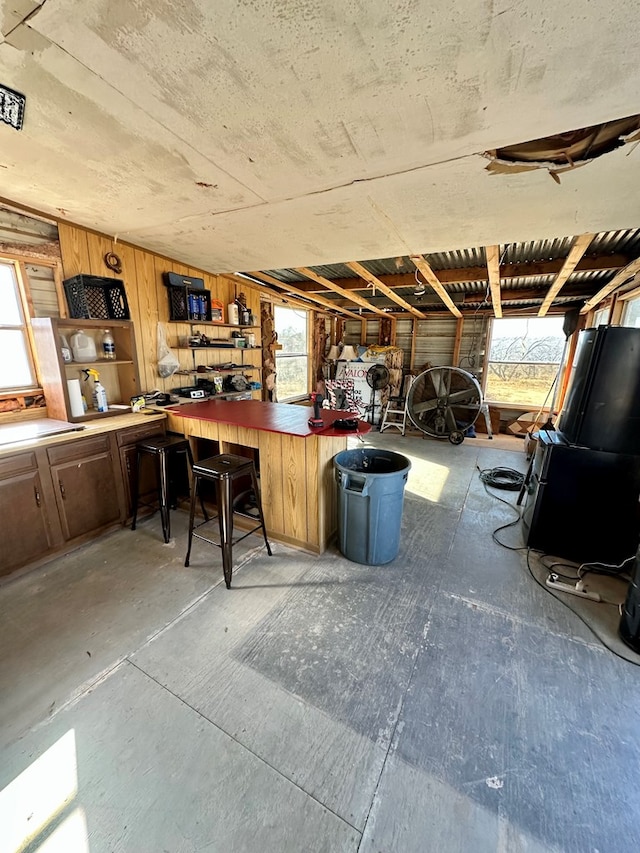 interior space featuring a workshop area, a wealth of natural light, and wood walls