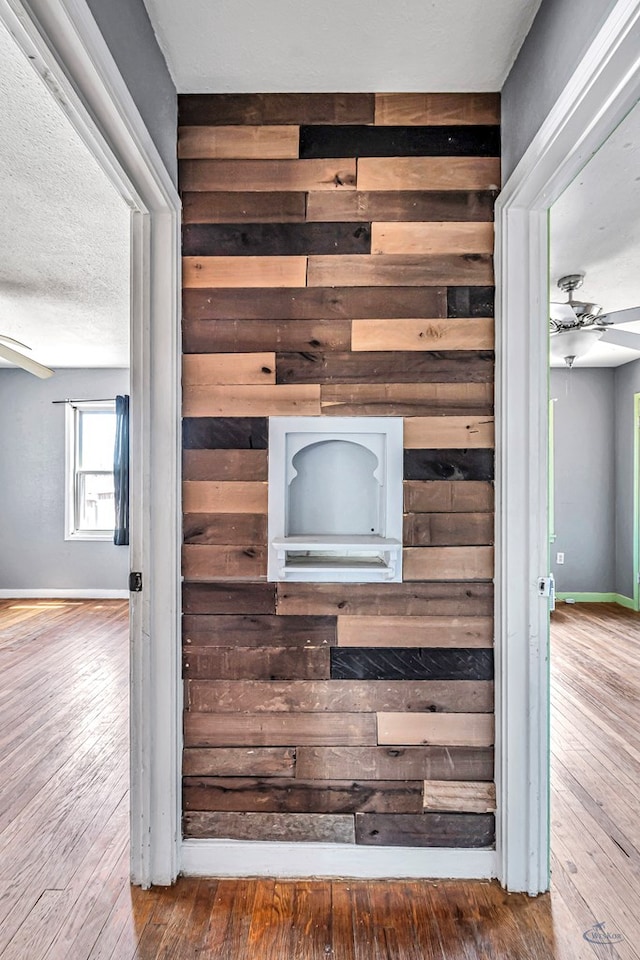 2109 Holloway Ave, Midland, TX 79705 - detailed view of wood walls, wood finished floors, baseboards, and ceiling fan