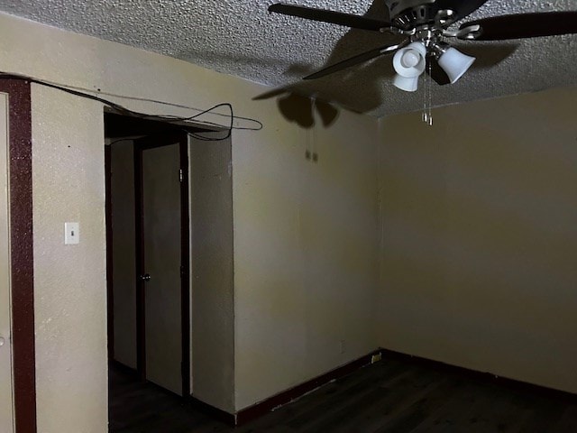 spare room featuring ceiling fan, dark hardwood / wood-style flooring, and a textured ceiling