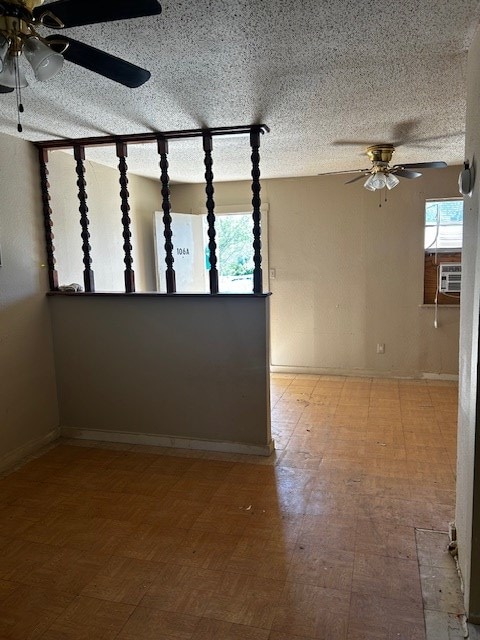 unfurnished room featuring hardwood / wood-style flooring, ceiling fan, cooling unit, and a textured ceiling