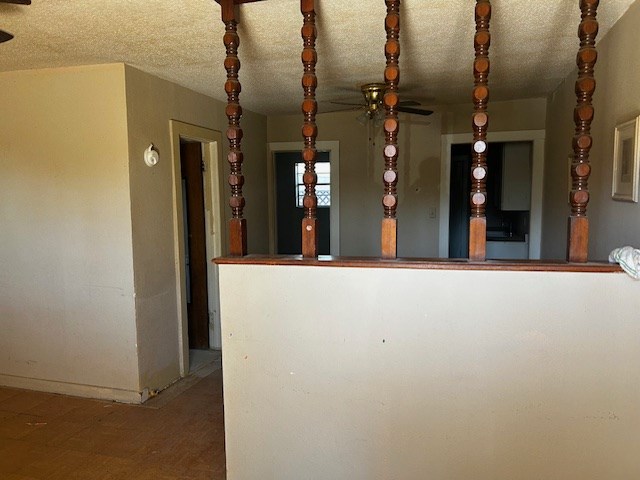 interior space with ceiling fan and a textured ceiling