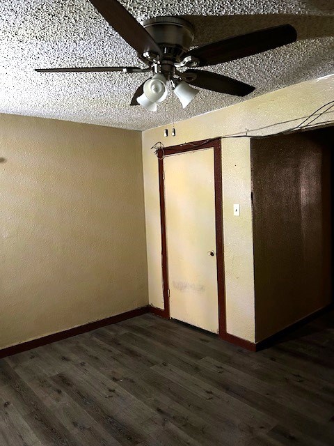 unfurnished bedroom featuring ceiling fan and dark hardwood / wood-style floors