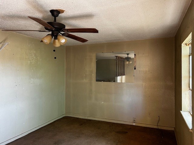 empty room with a textured ceiling and ceiling fan