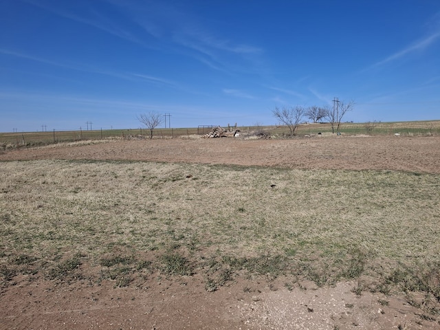 view of yard with fence and a rural view