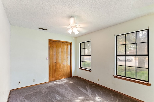 3400 Dentcrest Dr, Midland, TX 79707 - unfurnished bedroom with carpet flooring, multiple windows, a closet, a textured ceiling, and a ceiling fan