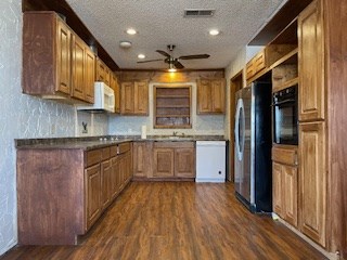 kitchen with ceiling fan, dark hardwood / wood-style flooring, tasteful backsplash, white appliances, and a textured ceiling