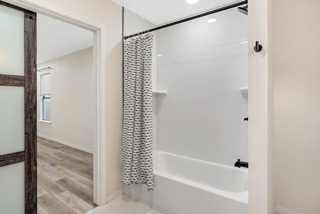 bathroom with hardwood / wood-style floors and shower / tub combo