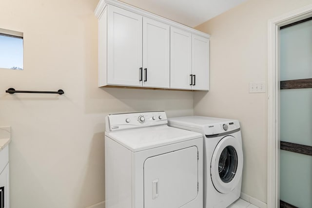 clothes washing area featuring cabinets and washing machine and dryer