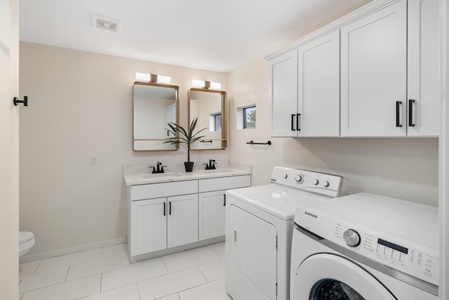 clothes washing area featuring light tile patterned flooring, sink, and washing machine and clothes dryer