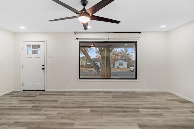 foyer entrance with ceiling fan and light wood-type flooring