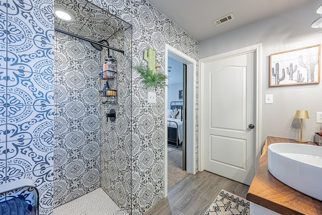 2108 S County Rd 1086, Midland, TX 79706 - bathroom featuring tiled shower, wood finished floors, and vanity