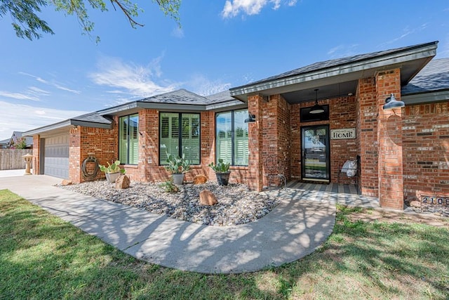 2108 S County Rd 1086, Midland, TX 79706 - view of front of house featuring brick siding, a garage, and a shingled roof