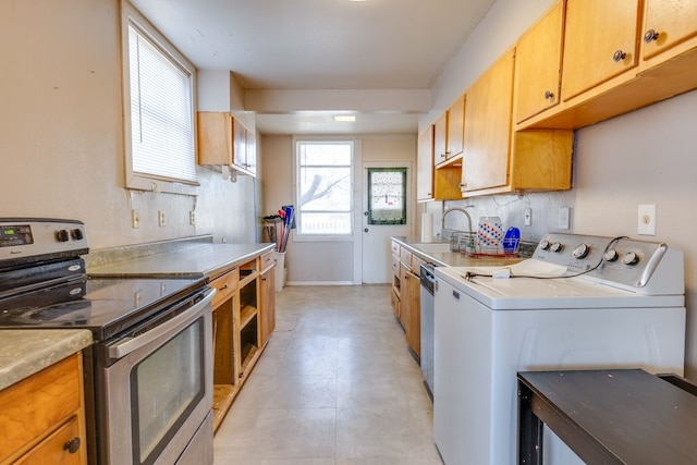 kitchen with electric stove, light countertops, washing machine and dryer, a sink, and dishwashing machine