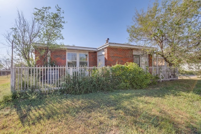 view of front of home with a front lawn, fence, and brick siding