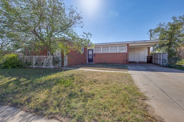 single story home with a front lawn, driveway, fence, and brick siding