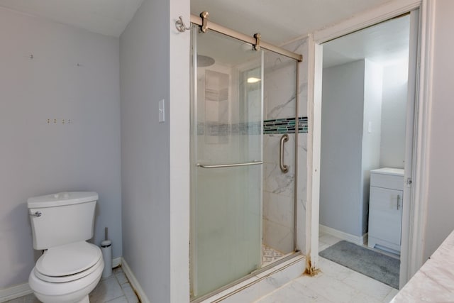 bathroom with a shower stall, vanity, toilet, marble finish floor, and baseboards