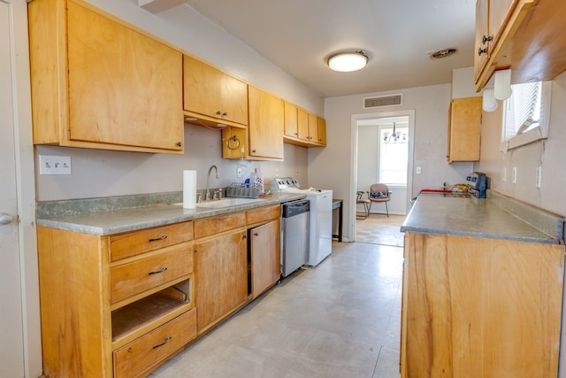 kitchen featuring stainless steel dishwasher, washer / clothes dryer, a sink, visible vents, and light floors