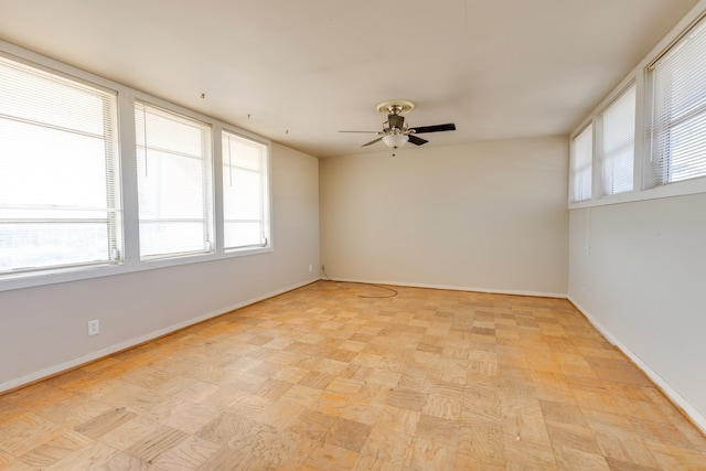 spare room with a healthy amount of sunlight, baseboards, and ceiling fan