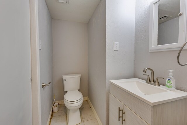 bathroom with toilet, tile patterned floors, visible vents, and vanity