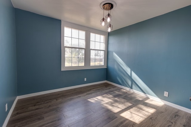 empty room featuring wood finished floors and baseboards